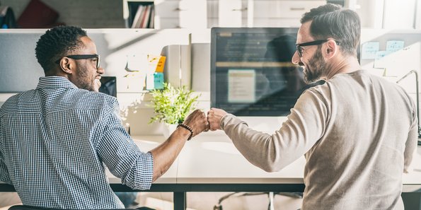 Zwei Männer geben sich im Büro einen Handschlag