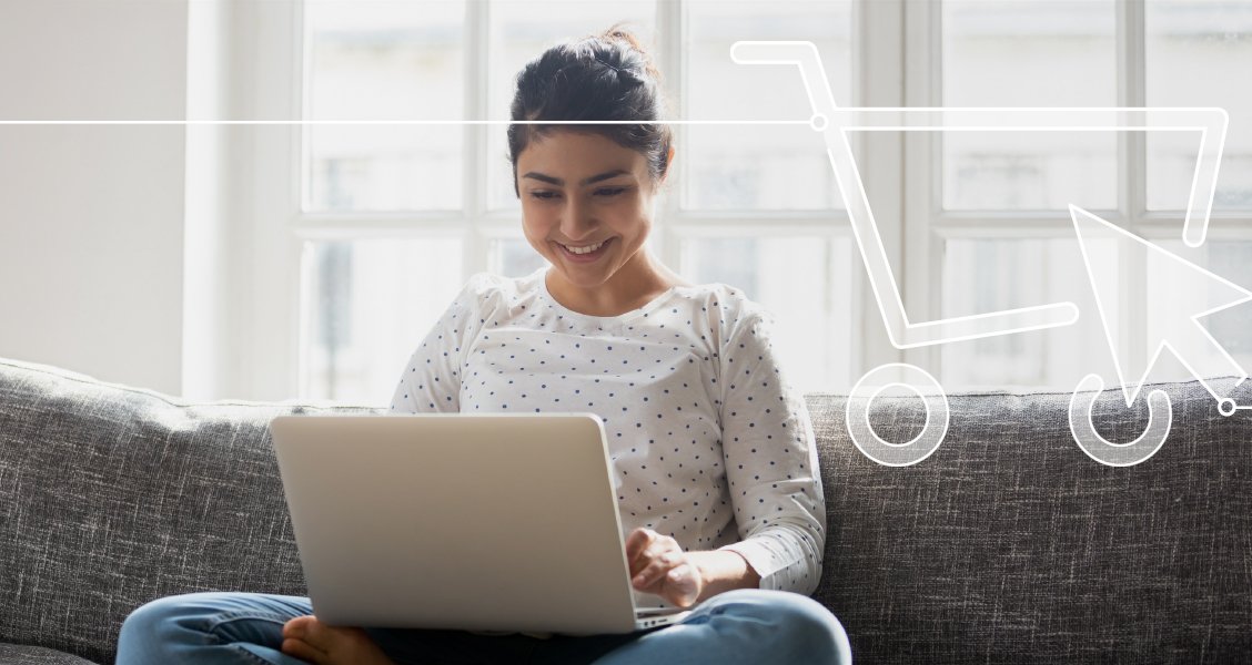 Zur Darstellung des Lehrgangs zum Zertifzierten GS1 Online Category Manager zeigt das Bild eine junge Frau, die im Schneidersitz mit einem Notebook auf dem Schoß auf dem Sofa sitzt 