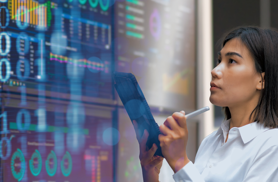 Das Bild zeigt zur Visualisierung des Lehrgangs zum Zertifizierten GS1 Data Quality Managers eine Frau, die auf eine Wand voller Daten schaut und dabei Notizen auf einem Block macht.