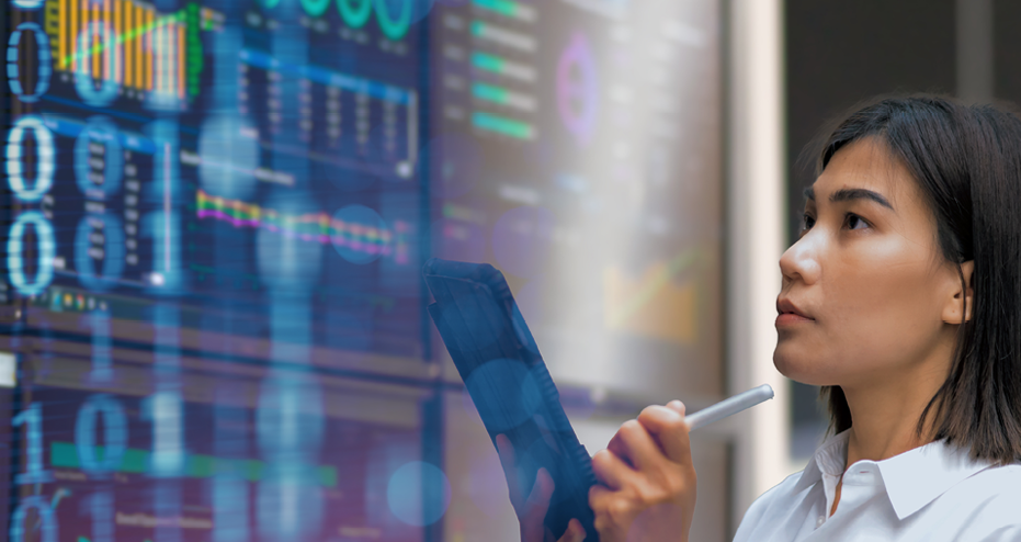 Das Bild zeigt zur Visualisierung des Lehrgangs zum Zertifizierten GS1 Data Quality Managers eine Frau, die auf eine Wand voller Daten schaut und dabei Notizen auf einem Block macht.