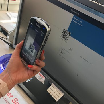 Foto: Handy scannt QR Code auf einem Monitor