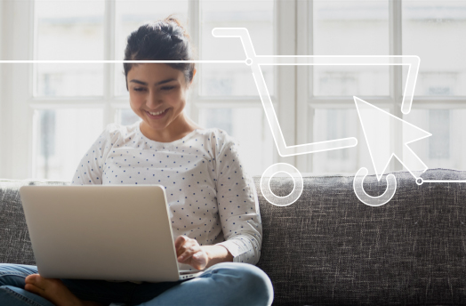 Zur Darstellung des Lehrgangs zum Zertifzierten GS1 Online Category Manager zeigt das Bild eine junge Frau, die im Schneidersitz mit einem Notebook auf dem Schoß auf dem Sofa sitzt 